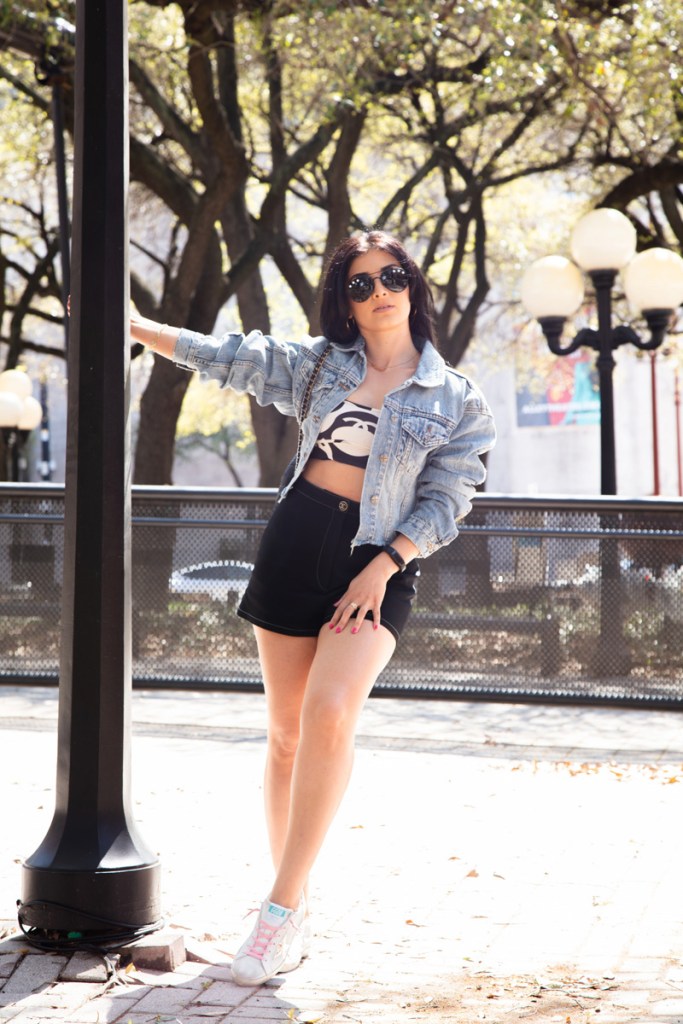 Sporty chic in Chanel silk crop top, black high-waisted shorts and Golden Goose. Givenchy star aviators